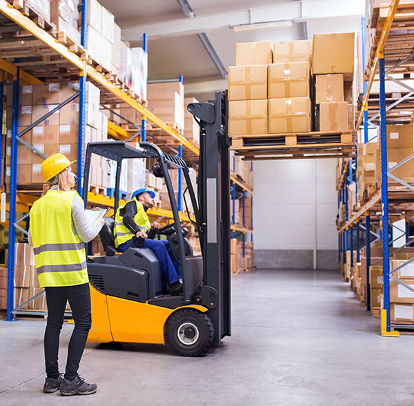 Young warehouse workers working together.