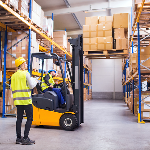 Young warehouse workers working together.