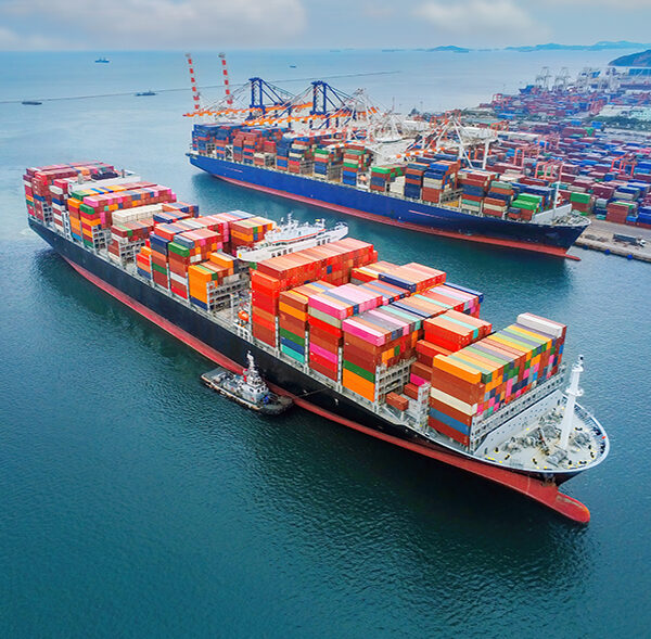 Arial view by drone camera transportation logistics and container dock cargo yard with working crane bridge in shipyard with transport logistic import export with blue sky background.