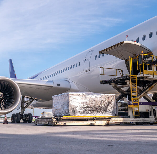 Air cargo logistic containers are loading to an airplane. Air transport shipment prepare for loading to modern freighter jet aircraft at the airport.